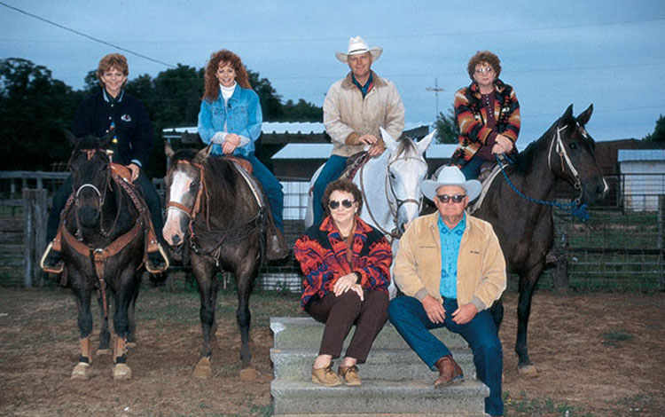 Reba McEntire and her family posing horseback at their family ranch in Oklahoma.